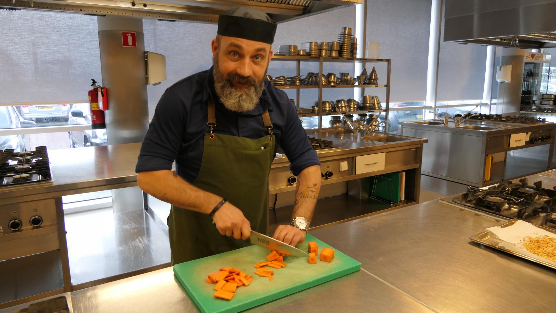 Deelnemer Erik bereidt een maaltijd in de keuken